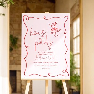 a sign with a red border and text inviting guests to a "Hens Party" on Saturday, 18th of October at two o'clock in the afternoon.