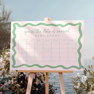 a large calendar board with a green border, displaying the days of the week and the date of the arrival of a baby named Baby Adams.