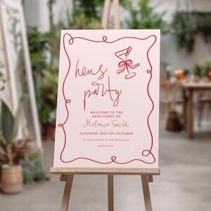 a signboard with a red and white design, welcoming guests to a party.