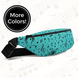May include: A turquoise blue fanny pack with a black adjustable strap. The fanny pack is covered in a pattern of black musical notes. The text "More Colors!" is written in a circle on the top left of the image.