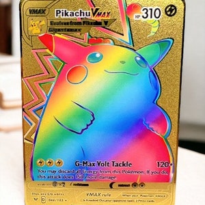 May include: A gold-colored Pikachu VMAX trading card with a rainbow gradient design. The card features the text "Pikachu VMAX" and "G-Max Volt Tackle". The card has a HP of 310 and a damage rating of 120+.