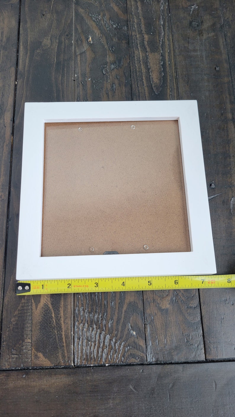 May include: White picture frame with a brown mat. The frame is 8 inches wide and 10 inches tall.