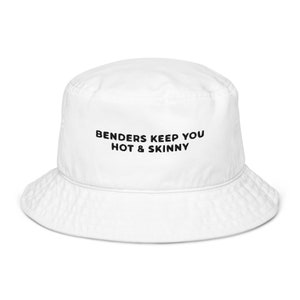Op de afbeelding: Witte bucket hat met zwarte tekst die "Benders keep you hot & skinny" zegt.
