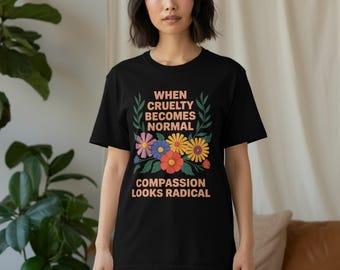 May include: Black t-shirt with the text "WHEN CRUELTY BECOMES NORMAL COMPASSION LOOKS RADICAL" in orange and white. The design includes colorful flowers and green leaves.