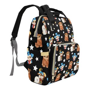 May include: A black canvas backpack with a colorful print of cartoon creatures. The backpack has a large main compartment, a front pocket, and two adjustable straps.