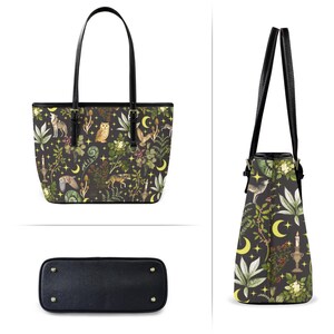 May include: Black tote bag with a whimsical forest print featuring wolves, owls, and botanical elements. The bag has black handles and a black base. The design includes yellow moons and stars, creating a mystical aesthetic.