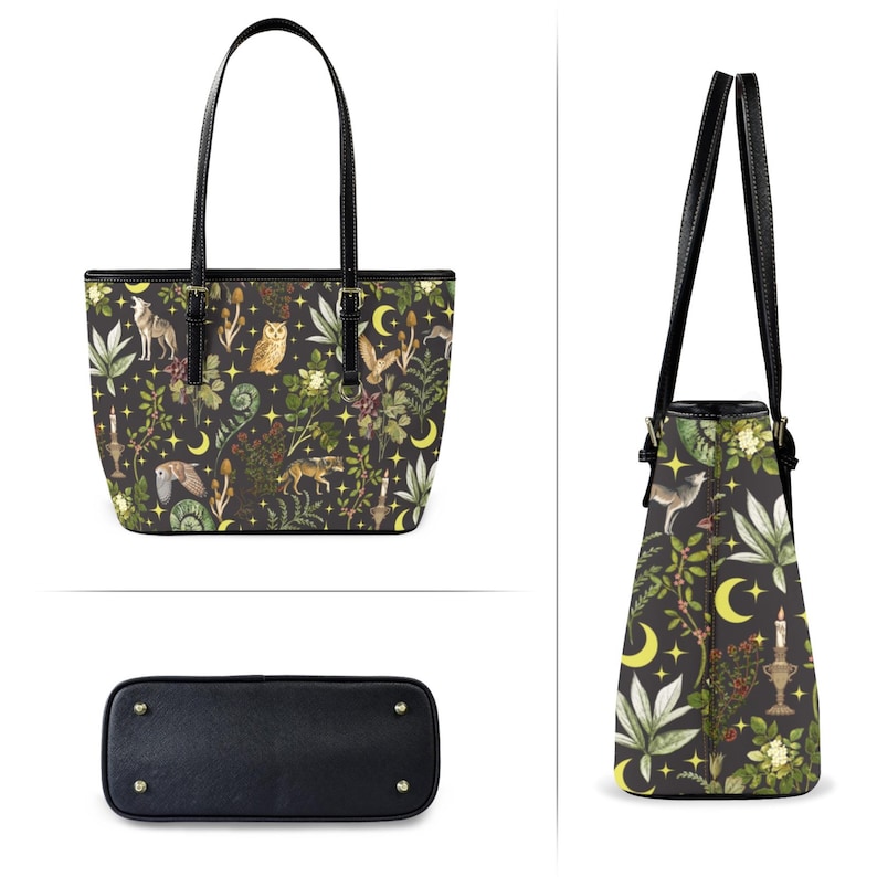 May include: Black tote bag with a whimsical forest print featuring wolves, owls, and botanical elements. The bag has black handles and a black base. The design includes yellow moons and stars, creating a mystical aesthetic.