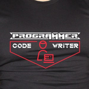 May include: Black t-shirt with a red and white graphic. The graphic reads "PROGRAMMER CODE WRITER" and features a stylized person with a laptop. The shirt is made of a soft material.
