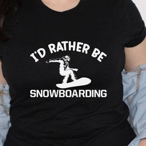 May include: Black t-shirt with white text that reads "I'd rather be snowboarding" and a silhouette of a person snowboarding.