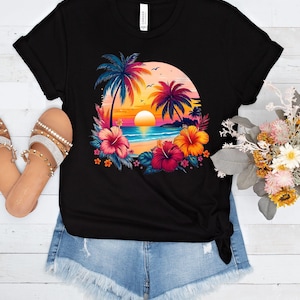 May include: Black t-shirt with a colorful graphic of palm trees, a sunset, and flowers on a beach.