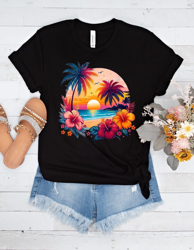 May include: Black t-shirt with a colorful graphic of palm trees, a sunset, and flowers on a beach.