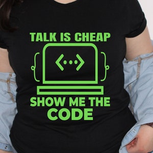 May include: Black t-shirt with green text that reads "TALK IS CHEAP {<..>} SHOW ME THE CODE".