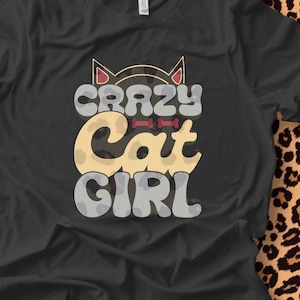 May include: Black t-shirt with a graphic design of a cat with the text "Crazy Cat Girl" in a retro font.
