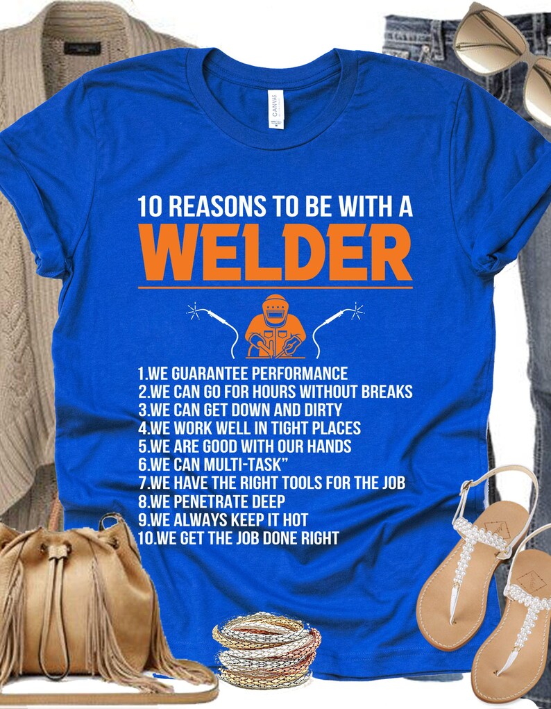 May include: A royal blue t-shirt with the text "10 REASONS TO BE WITH A WELDER" in orange. The shirt features a graphic of a welder and a list of reasons. The shirt is displayed with accessories.