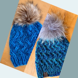 May include: Two blue knitted hats with faux fur pom poms. One hat is a solid blue colour and the other is a blue and green colour.