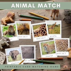 Puede incluir: Una mesa de madera exhibe un juego "ANIMAL MATCH" con tarjetas de animales, figuras de animales de madera y lápices de colores. El juego incluye tarjetas con imágenes de un león, una jirafa, un elefante y un guepardo. El texto "PRINTABLE CARD MATCHING GAME" también es visible.
