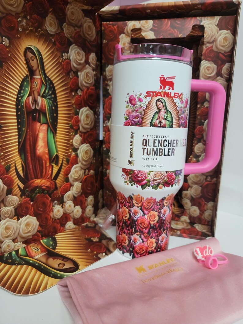 May include: A white 40 oz Stanley Flowstate Quencher H2O tumbler featuring a graphic of Our Lady of Guadalupe surrounded by roses, a pink handle, and a pink lid. The tumbler is displayed with a matching floral box and a pink fabric accessory.