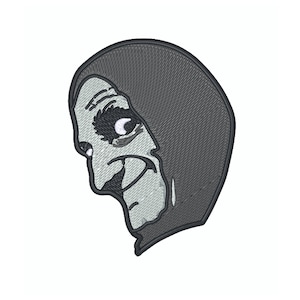 Op de afbeelding: Gestikte patch van een cartoonheks met een ondeugende grijns, die een donkergrijze capuchonmantel draagt. De heks heeft een groot oog en een kromme neus.