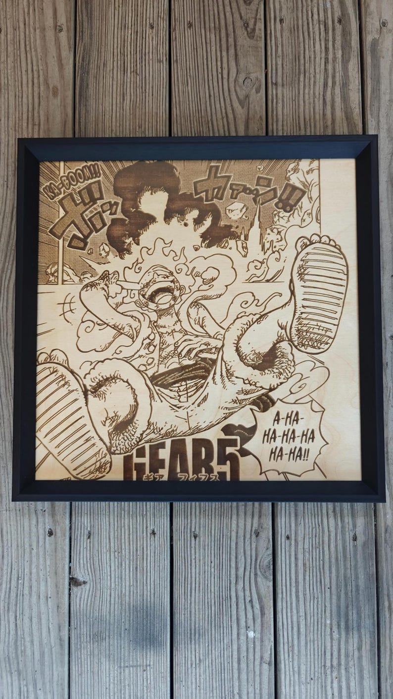 May include: Wooden framed artwork featuring a detailed wood-burned illustration of a manga character in a dynamic pose. The artwork includes Japanese text and sound effects, with the word "GEAR5" prominently displayed. The frame is black.