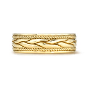 May include: A gold wedding band with a braided design.