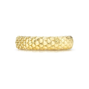 May include: A gold band ring with a textured surface that resembles scales.