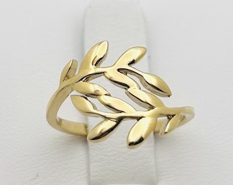 Könnte beinhalten: Ein goldener Ring mit einem zarten Blattdesign. Der Ring ist aus einem einzigen Stück Metall gefertigt und hat einen schlichten, eleganten Stil.