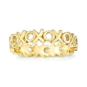 May include: A gold-colored ring with a repeating pattern of "XOXO" symbols. The ring is made of a shiny, polished metal and has a continuous design. The ring is a fashion accessory.