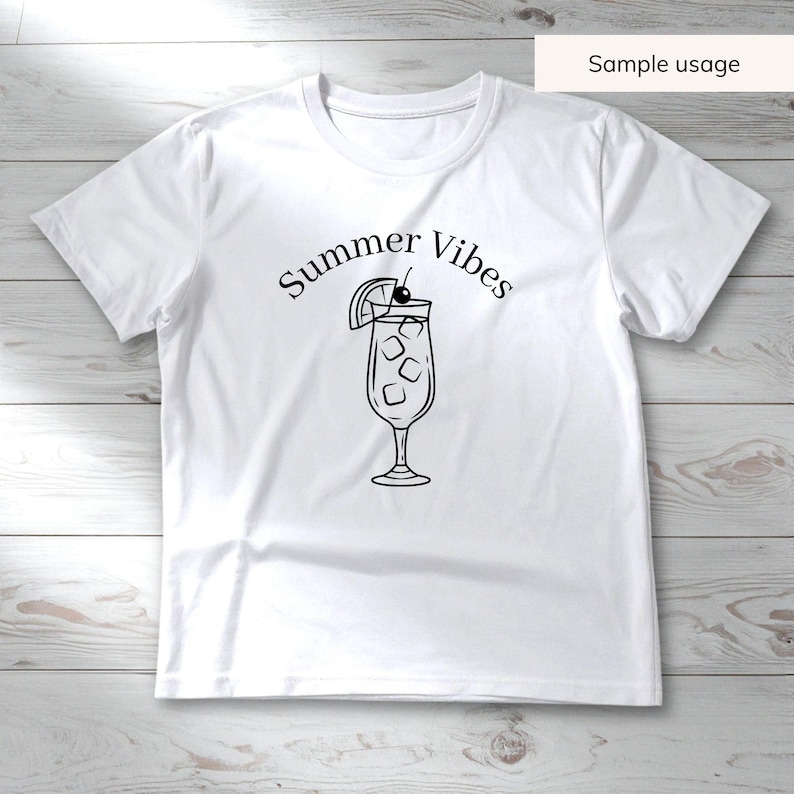 May include: White t-shirt with a black graphic of a cocktail with ice, a cherry, and a lemon slice. The words "Summer Vibes" are arched above the drink. The shirt is made of a soft material and is suitable for casual wear.