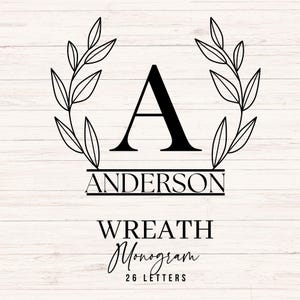 May include: A black monogram design featuring the letter "A" above the name "ANDERSON" and the words "WREATH Monogram" with "26 LETTERS" below. The design includes a wreath of leaves and is set against a white wood grain background.