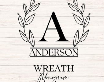May include: A black monogram design featuring the letter "A" above the name "ANDERSON" and the words "WREATH Monogram" with "26 LETTERS" below. The design includes a wreath of leaves and is set against a white wood grain background.