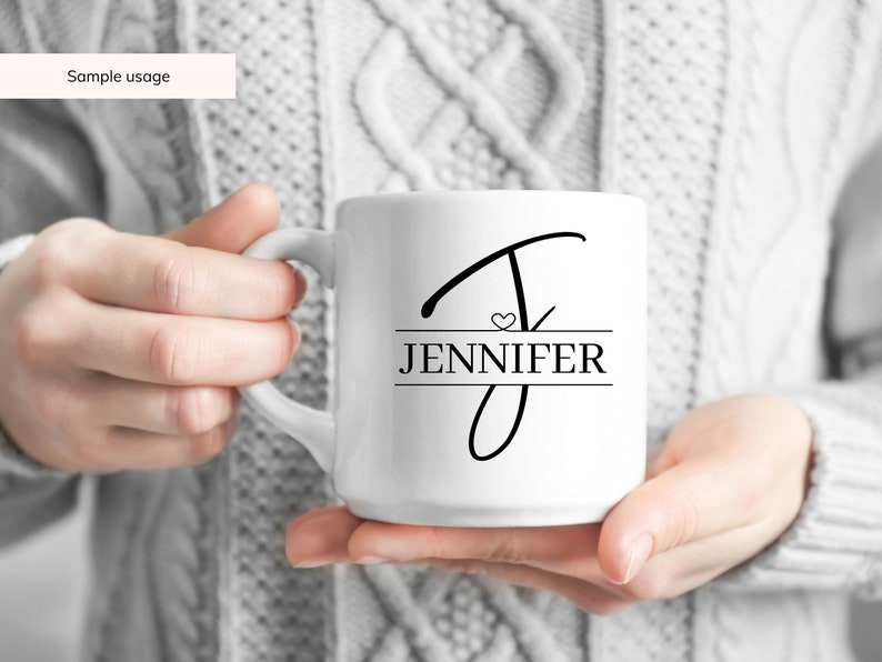 Peut inclure: Une tasse en c&eacute;ramique blanche avec un motif noir et blanc. Le motif repr&eacute;sente une lettre stylis&eacute;e "J" avec un petit c&oelig;ur et le nom "JENNIFER" imprim&eacute; en dessous.