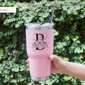 May include: A pink stainless steel tumbler with a black floral monogram design featuring the letter "B" and the name "BRENDA".