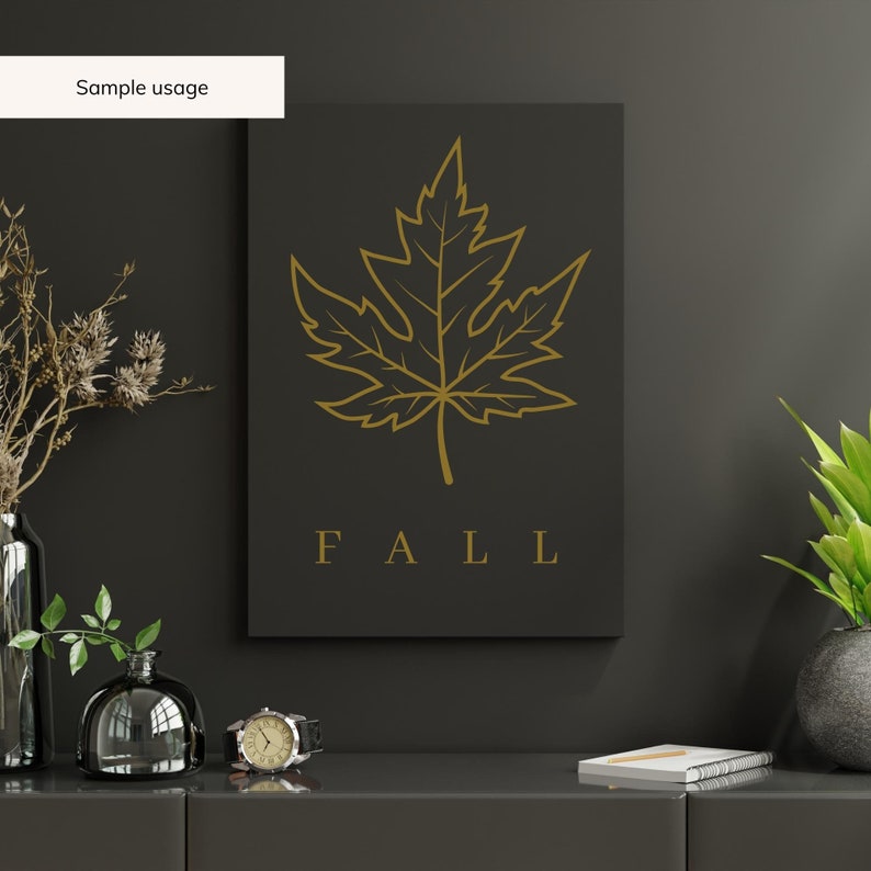 May include: A black and gold printable wall art design featuring a stylized maple leaf and the word "FALL" in gold lettering.