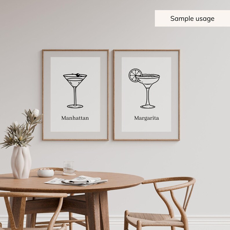 May include: Two framed art prints featuring cocktail illustrations. One shows a Manhattan cocktail with an olive, the other a Margarita with a lime slice. Each print has a minimalist black and white design with the cocktail name below.