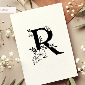 May include: A black floral monogram letter R with white flowers and leaves. The letter is on a white background.