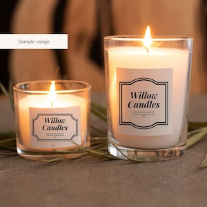May include: Two glass candle jars with white candles and black labels that say "Willow Candles". The labels have a decorative border and include the address "21-B Sunrise Apartments #229, Oceanside Ave Kapiolani, Hawaii 96710".
