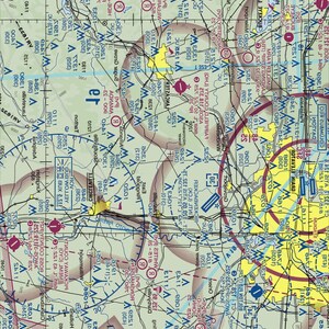 May include: A detailed sectional aeronautical chart with various symbols, lines, and text. The map features a complex layout with different colors, including blue, yellow, and green, indicating various geographical and navigational elements. The chart is designed for aviation use.
