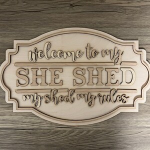 May include: Wooden sign with the text "Welcome to my SHE SHED my shed my rules" in a decorative font.