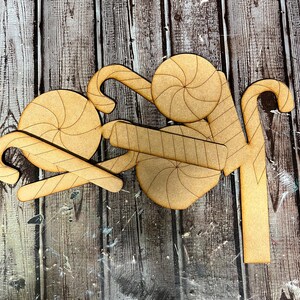May include: Wooden craft cutouts of candy canes and peppermint candies. The cutouts are unfinished and ready to be painted or decorated.