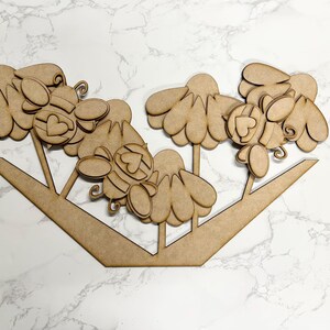 May include: Wooden craft kit featuring a bee-themed design with multiple pieces to assemble. The kit includes a beehive, flowers, and bees with hearts on their bodies.