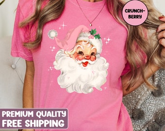 May include: Pink t-shirt featuring a vintage illustration of Santa Claus with a pink hat and white beard. The shirt has the text "CRUNCH-BERRY" in a white box on the right side of the image. The text "PREMIUM QUALITY FREE SHIPPING" is at the bottom of the image.