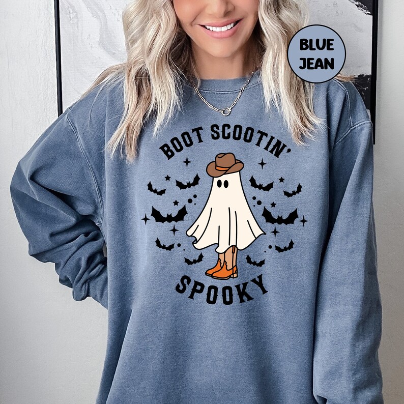 May include: A blue sweatshirt with the text "Boot Scootin' Spooky" and a cartoon ghost wearing a cowboy hat and boots.