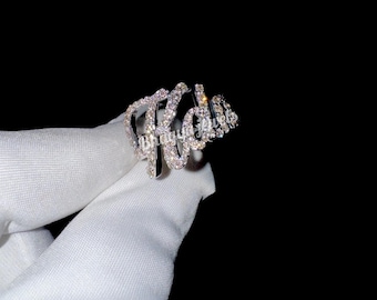 May include: A silver ring with the word "Kalia" spelled out in sparkling rhinestones.