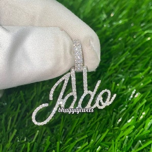 May include: A silver pendant with the name "Jada" spelled out in diamonds. The pendant is on a white background.