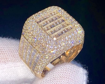 May include: A gold ring with a square face set with small round and baguette-shaped diamonds.
