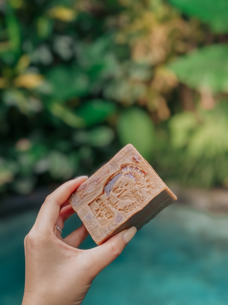 May include: A brown bar of soap with a raised design of a tree and the text "LOVE" on it.