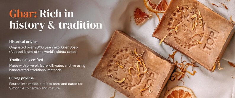 May include: Two bars of brown soap with a textured surface and a label that says "TOP". The soap is surrounded by dried orange peels and petals.