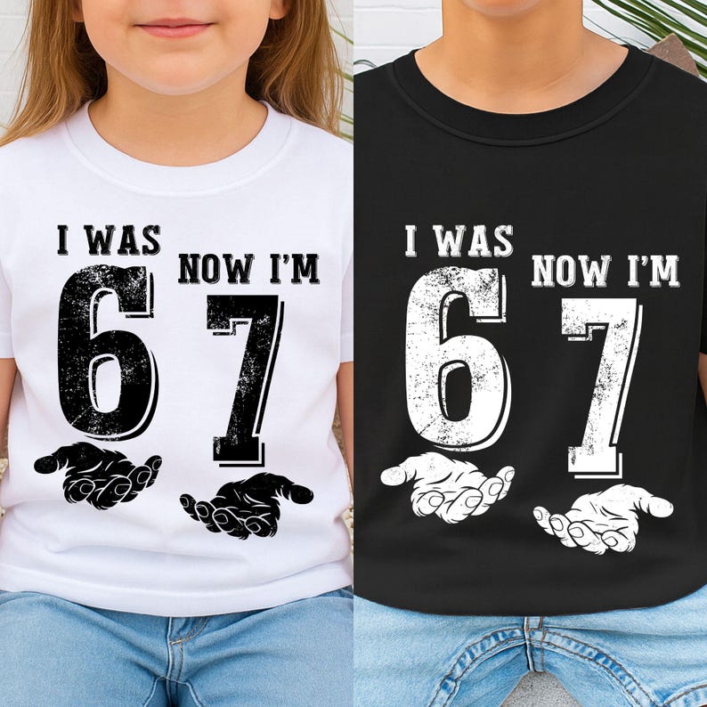 May include: White and black t-shirts with the text "I WAS 6 NOW I'M 7" printed on the front. The number 6 and 7 are large and bold, with a distressed texture. Below the numbers are two hands. The shirts are worn by children.