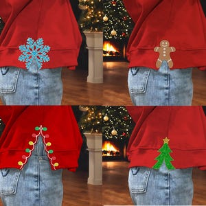 Op de afbeelding: Vier rode sweatshirts met verschillende kerstthema-ontwerpen op de rug. De ontwerpen omvatten een sneeuwvlok, een peperkoekman, een lichtsnoer en een kerstboom.