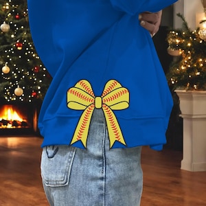 Peut inclure: Un sweat-shirt bleu royal avec un nœud de softball jaune et rouge au dos. Le nœud est noué et les extrémités du nœud pendent.